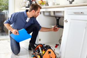 plumber-inspecting-pipes-kitchen